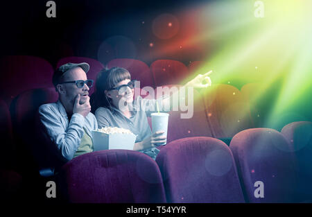 Teenager couple cuddling and watching the climax part of the movie Stock Photo