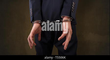 Close now arrested men hand with dark background and handcuffs  Stock Photo