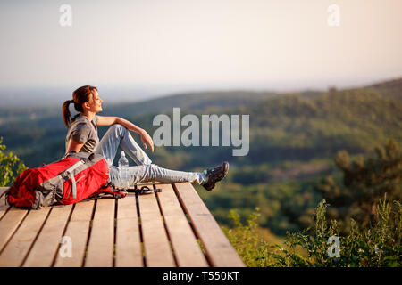 Young female hiker enjoying on the sun on break from hiking Stock Photo