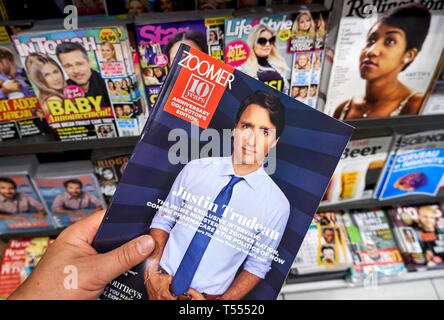 MONTREAL, CANADA - OCTOBER 9, 2018: Zoomer magazine with Canadian Prime Minister Justin Trudeau in a hand over a stack of magazines.