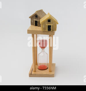 Real estate investment concept. Sand glass and miniature house Stock Photo