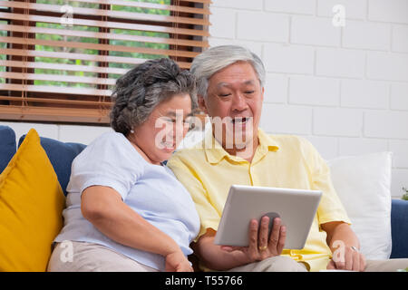 happy Asian senior couple use tablet video chatting to family at home.aging at home concept