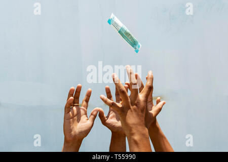 Hands trying to get or catch the flying money on isolated background. Stock Photo