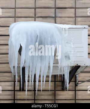the external unit of the air conditioner is covered with large icicles. Incorrect use of the air conditioner and poor thermal insulation leads to the  Stock Photo