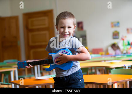 Little boy is playing on a toy guitar. Talented boy future musician Stock Photo