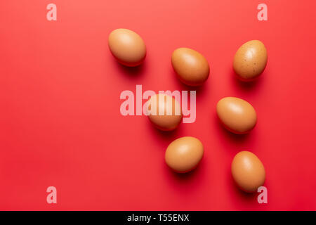 brown eggs texture on colored red background full frame Stock Photo