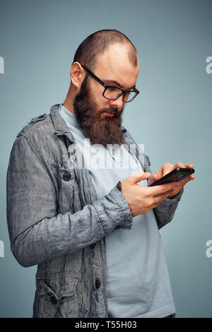 lifestyle brooding man with a beard and a telephone, background, copyspace. Stock Photo