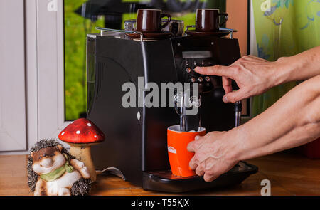 Two hands operate a coffee machine Stock Photo