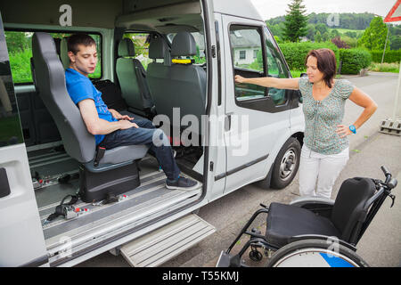 Handicapped boy is picked up by school bus Stock Photo