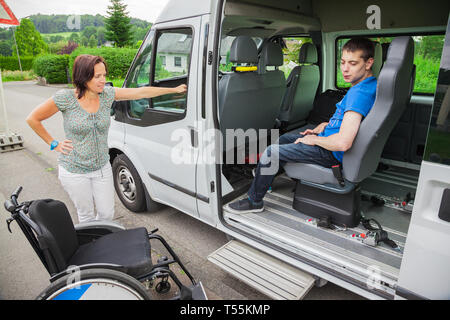 Handicapped boy is picked up by school bus Stock Photo