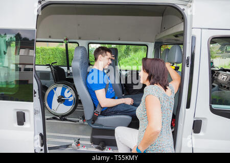 Handicapped boy is picked up by school bus Stock Photo