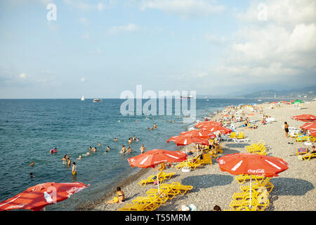 Batumi, Georgia August 2018: Coca Cola Umbrella On The Black Sea Beach with cloud sky on the background Stock Photo