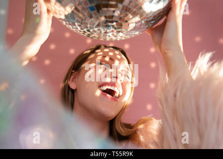 Smiling young woman holding mirror ball Stock Photo
