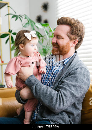 Smiling father holding his baby girl Stock Photo
