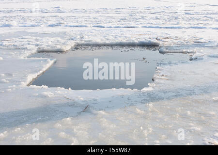 A pond in the icy lake in the form of a cross for the feast of the baptism of the Lord Stock Photo