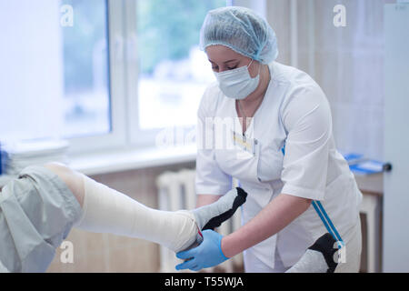 Nurse bandages a patient's leg Stock Photo