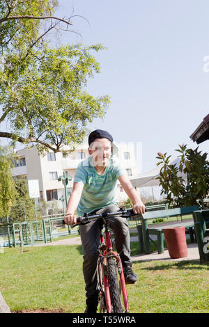 Teenage boy cycling in park Stock Photo