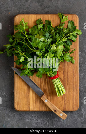 Bunch of parsley and knife on cutting board Stock Photo