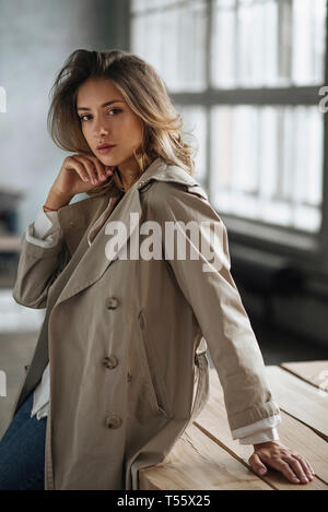 Young woman wearing grey trench coat Stock Photo