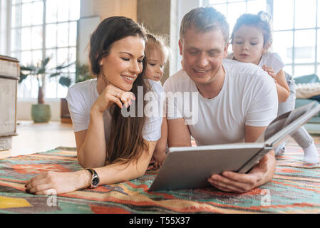 Parents and daughters reading picture book Stock Photo