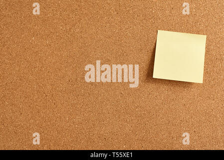 Cork board with yellow paper blank note, close up Stock Photo