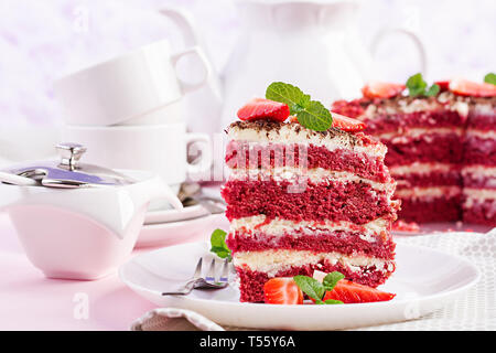 Red velvet cake on a pink background. Tea drinking. Table setting. Stock Photo