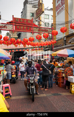 Thailand, Bangkok, Chinatown, Thanon Mangkon, man riding motorcycle through crowded shopping street Stock Photo