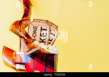 Movie tickets, film strips and popcorn on blue background. Copy space for text. Stock Photo