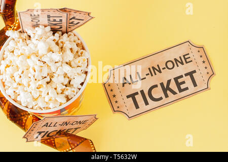 Movie tickets, film strips and popcorn on blue background. Copy space for text. Stock Photo