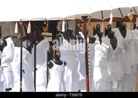 A line of mannequins displaying all white fashion in front of a French shop. Stock Photo