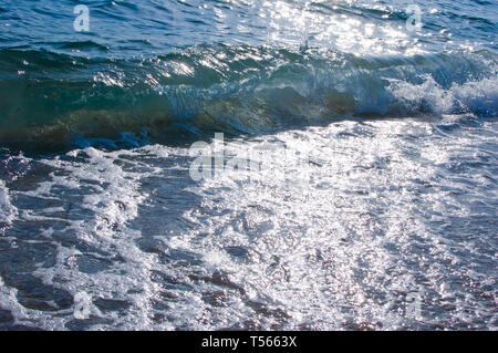 foam of splashing water with sun lights and sparkles  at late afternoon, background of foam and water, full frame Stock Photo