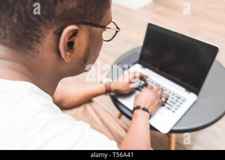 Young African American businessman remotely working at home on a laptop. Stock Photo