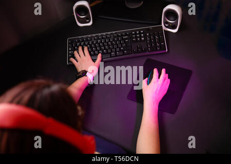 Female hands playing computer game with mouse and keyboard. Stock Photo