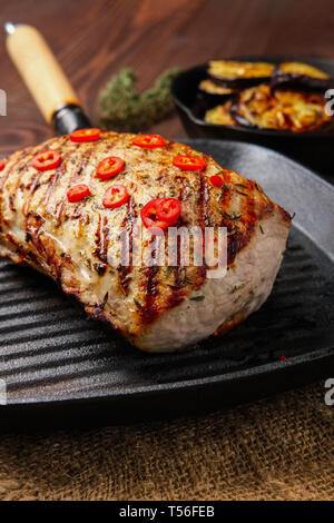Grilled striploin on grill pan and fried eggplant on wooden background Stock Photo