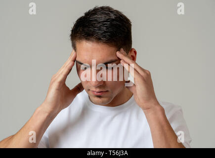 Close up portrait of handsome young latin mixed race man with headache suffering from migraines, hands on temples eyes closed showing strong pain. Med Stock Photo