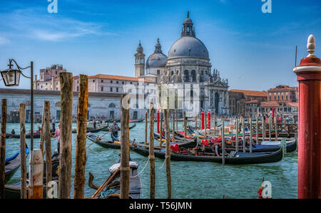 Venice, Italy - April 17 2019: Gondolas in Venice with Basilica di Santa Maria della Salute in background
