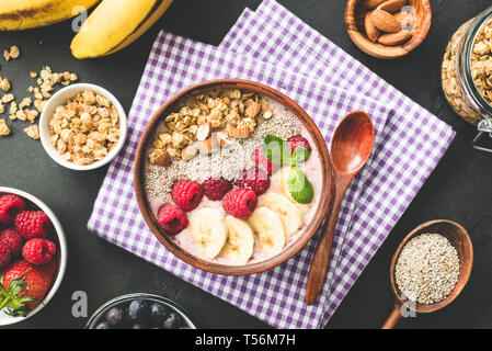 Smoothie bowl topped with berries, granola and chia seeds. Healthy vegan, vegetarian food. Top view, toned image Stock Photo