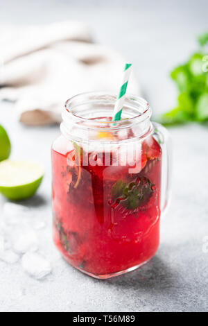 Red berry summer cocktail or ice tea in jar. Ice cold beverage. Vertical orientation Stock Photo