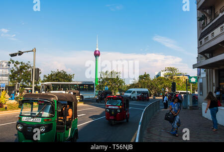 Colombo, Sri Lanka - April 5, 2019: Downtown Colombo street scene with Lotus tower in the background and tuk-tuk on the street with people passing by Stock Photo