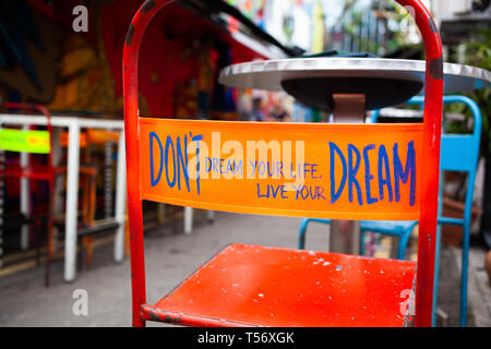 don't dream your life, live your dream - message on the back of a red chair Stock Photo