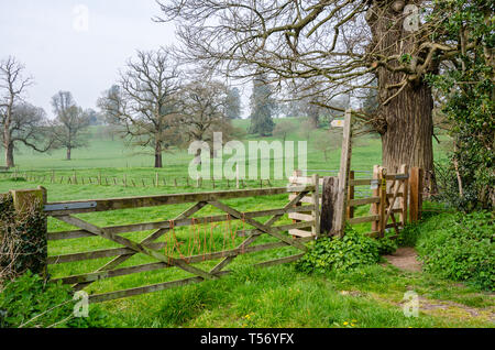 A wooden gate in a fence with access to a signposted public footpath through the Shropshire countryside at Worfield in Shropshire, UK Stock Photo