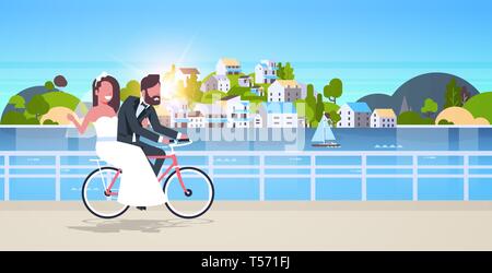 just married man woman riding bicycle romantic couple bride and groom cycling bike having fun wedding day concept mountain city island sunset Stock Vector