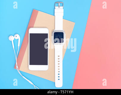 Empty mobile phone with smartwatch gadgets on blue  pink yellow Stock Photo