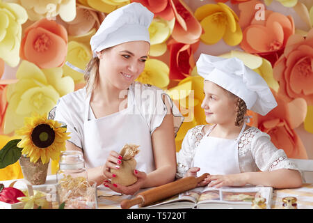 mom teaches little daughter to roll out the dough. the concept of parenting Stock Photo