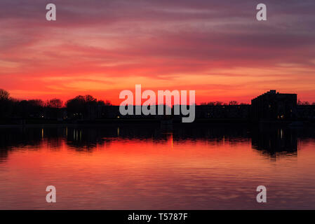 Paris, France. 21st Apr, 2019. Stunning sunset over the Lac de La Sourderie, in the south western Paris suburb of Montigny-le-Bretonneux. The view over-looks the residential area of Les Arcades du Lac, designed by Spanish architect Ricardo Bofill, and is known locally as ‘The Versailles for the People'. Credit: Francesca Moore/Alamy Live News Stock Photo