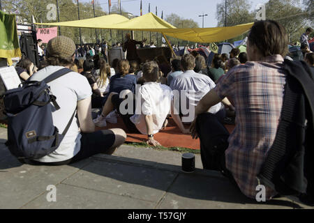 London, Greater London, UK. 20th Apr, 2019. Protesters are seen seated while listening to speeches during the protest.Climate change activists from the Extinction Rebellion camped at the Marble Arch in central London where all their activities such as music, artwork and classes are taking place from, after police officers cleared sites at the Oxford Circus, Waterloo Bridge and Parliament Square from Extinction Rebellion protesters. Extinction Rebellion demands the government for direct actions on the climate and to reduce carbon emissions to zero by 2025 and also the people's