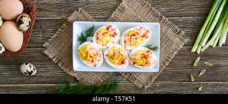 Deviled eggs. Delicious appetizer. Boiled eggs stuffed with yolk, mustard, mayonnaise, paprika. Classic recipe. The top view. Banner Stock Photo