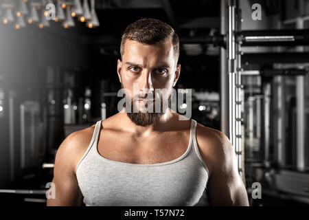 Bearded man bodybuilder standing at gym looking camera serious close-up Stock Photo