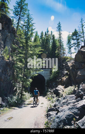 Man on a bike - on the Kettle Valley Rail Train - KVR - Kelowna, British Columbia, Canada. Bike path in Summer Stock Photo