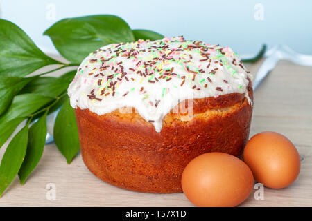 Easter cake and colored eggs on blue background. Holiday food and easter concept. Selective focus. Copyspase. Stock Photo